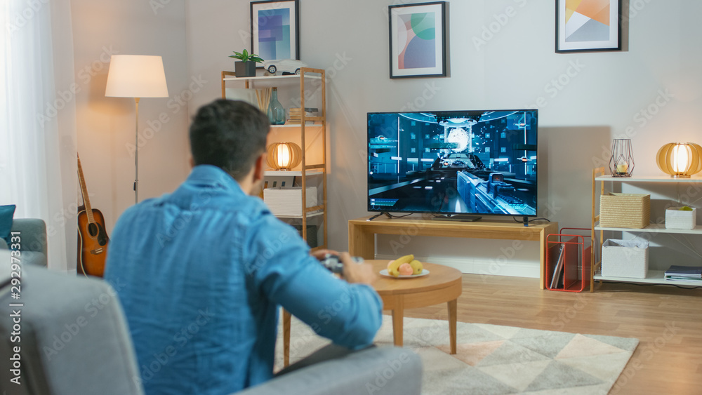 在客厅里，一个坐在沙发上的男人拿着控制器玩控制台视频游戏，3D Actio