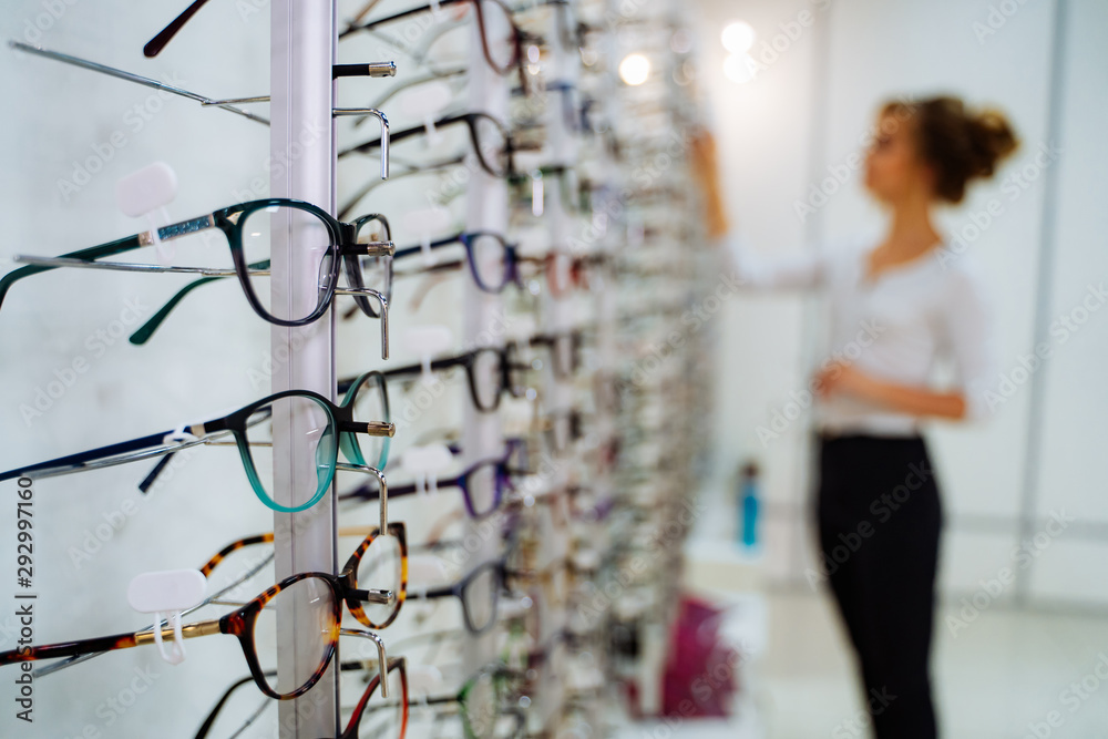 眼镜店。带着眼镜站在眼镜店。女人选择眼镜。
