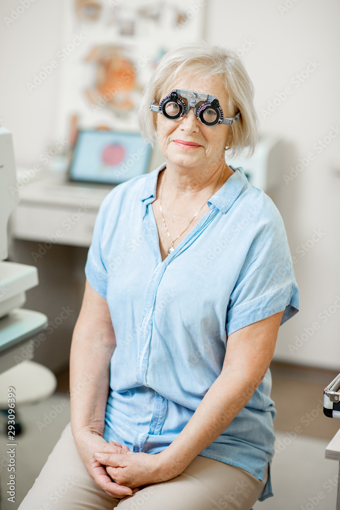Portrait of a senior woman checking vision with eye test glasses during a medical examination at the