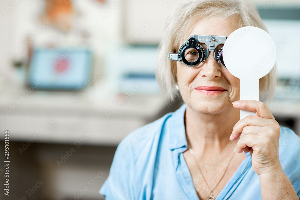 老年妇女在医院体检时用验眼眼镜和肩胛骨检查视力