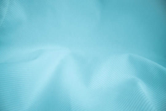 宏观镜头中闪闪发光的流动布料纹理。波浪状干净的丝绸编织材料。纺织品抽象背景