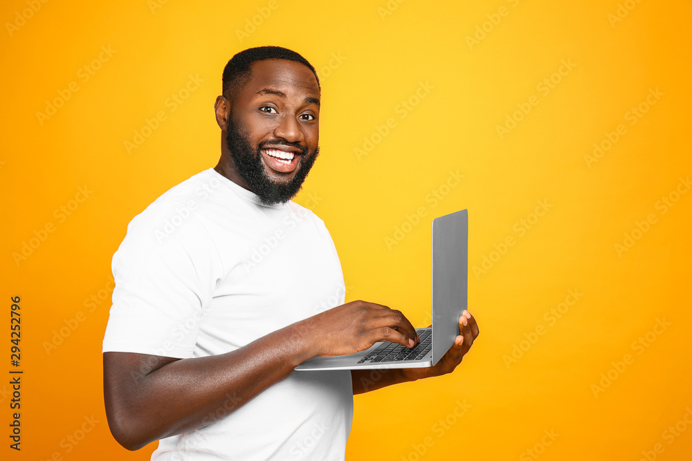带彩色背景笔记本电脑的英俊非裔美国人