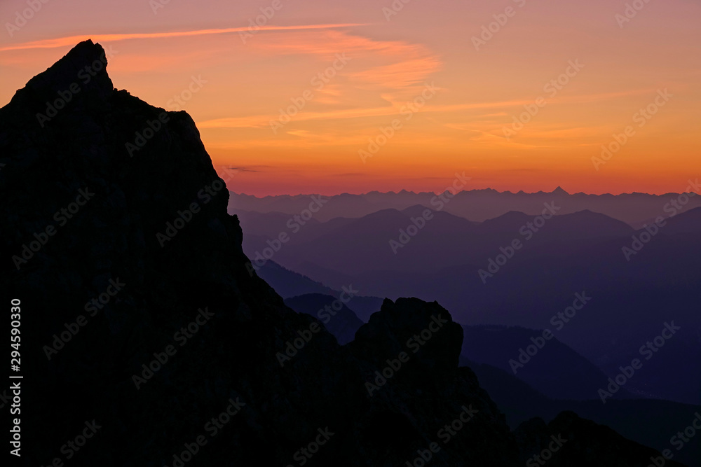 特写：黄昏时分，山顶高耸在黑暗景观之上的剪影。