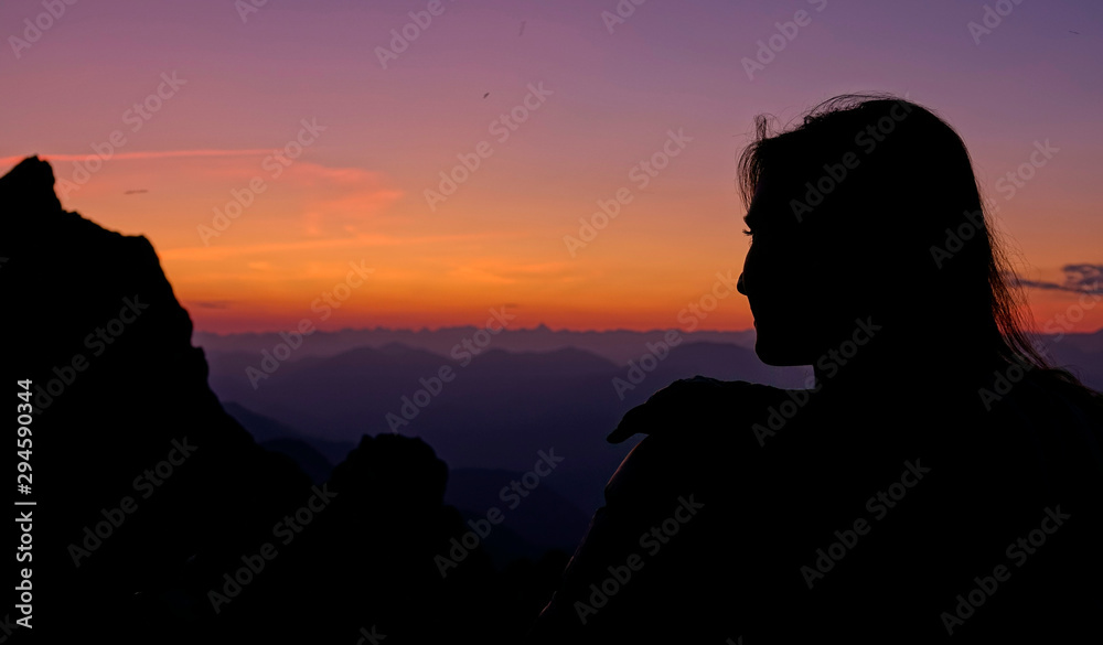 特写：年轻的女徒步旅行者在日落时从山顶观察朱利安阿尔卑斯山