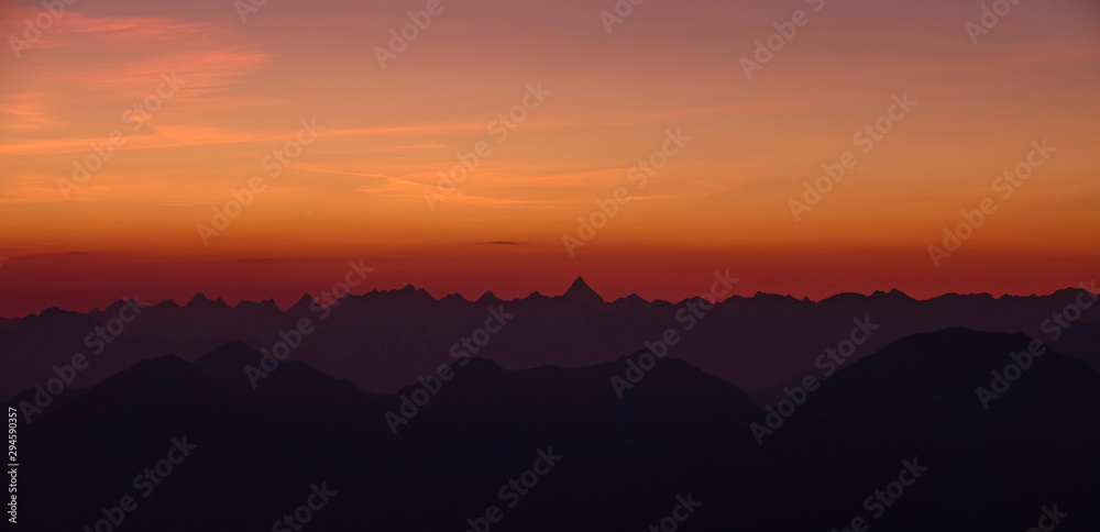 在风景如画的黎明时分，五彩缤纷的晨曦笼罩在无尽的岩石朱利安阿尔卑斯山之上。