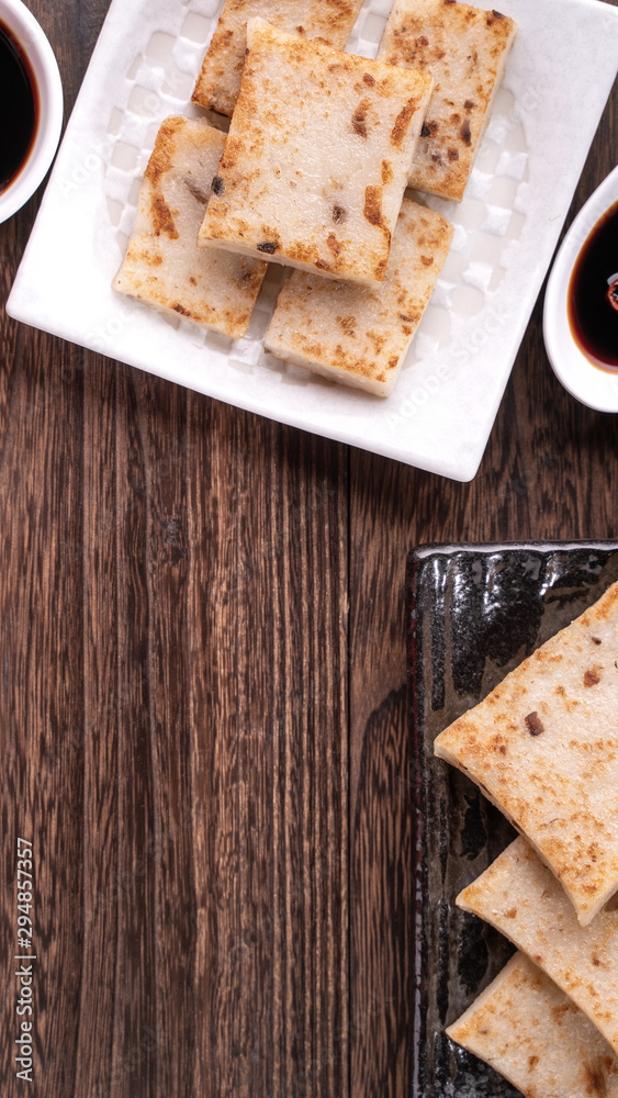 Delicious turnip cake, Chinese traditional local radish cake in restaurant with soy sauce and chopst