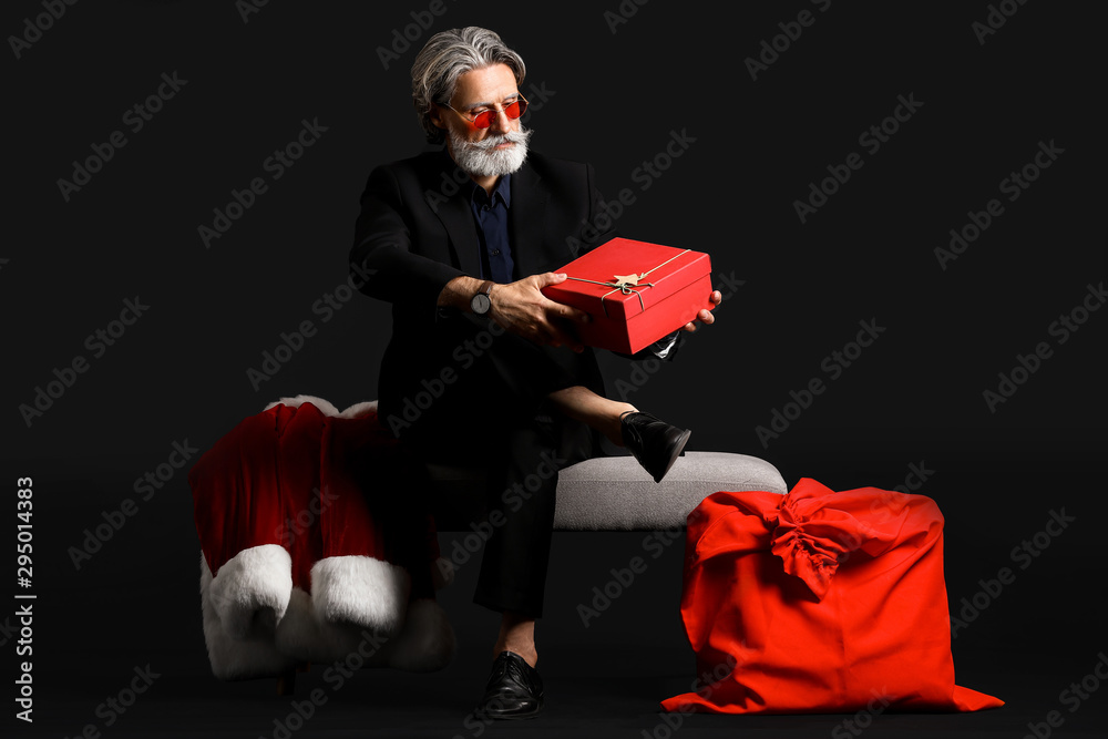 深色背景下带礼物的时尚圣诞老人肖像