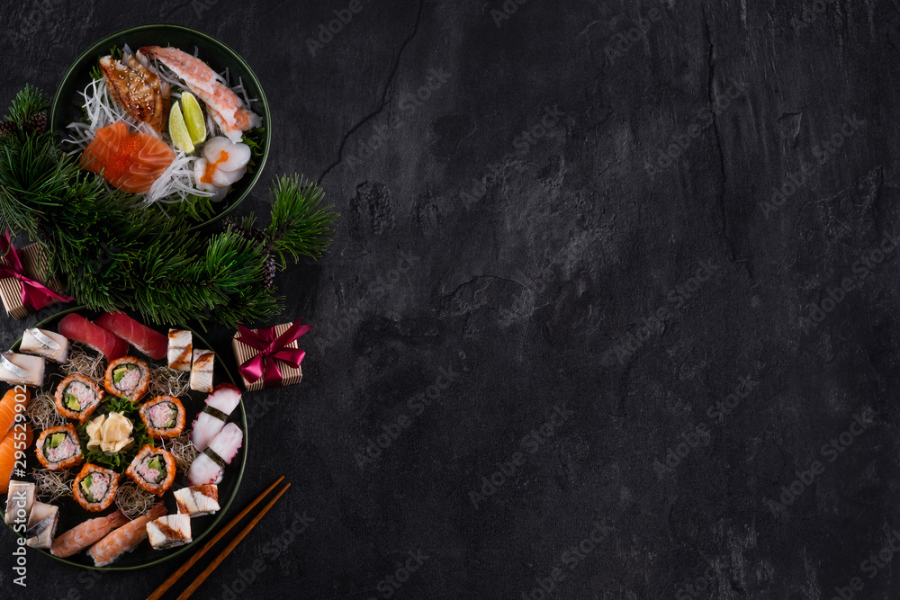 什锦寿司生鱼片，配三文鱼、金枪鱼和鳗鱼，深色石板背景，带装饰。克里