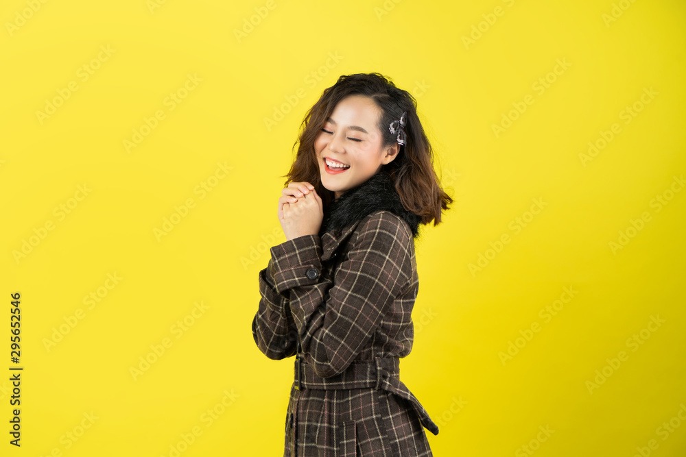 亚洲女人，她很开心。她有一个黄色的背景。