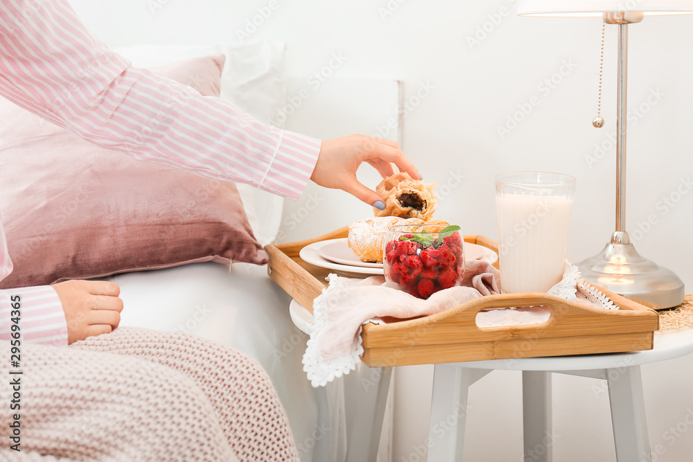 年轻女人在床上吃美味的早餐