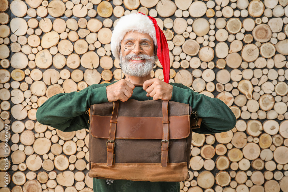 木制背景下带公文包的时尚圣诞老人肖像