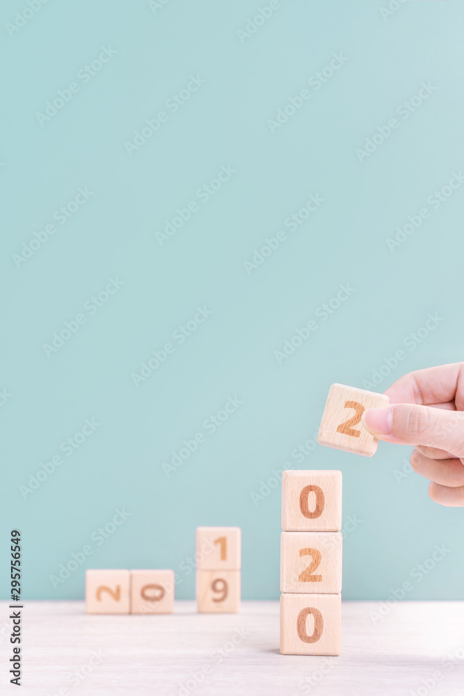 Abstract 2020 & 2019 New year countdown design concept - woman holding wood blocks cubes on wooden t