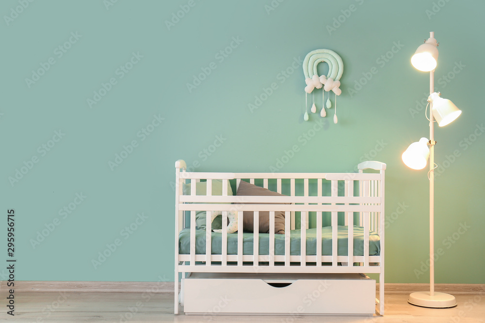 儿童房内部靠近彩色墙壁的带灯时尚婴儿床