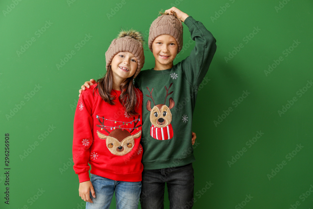 穿着圣诞毛衣和彩色背景针织帽的小孩