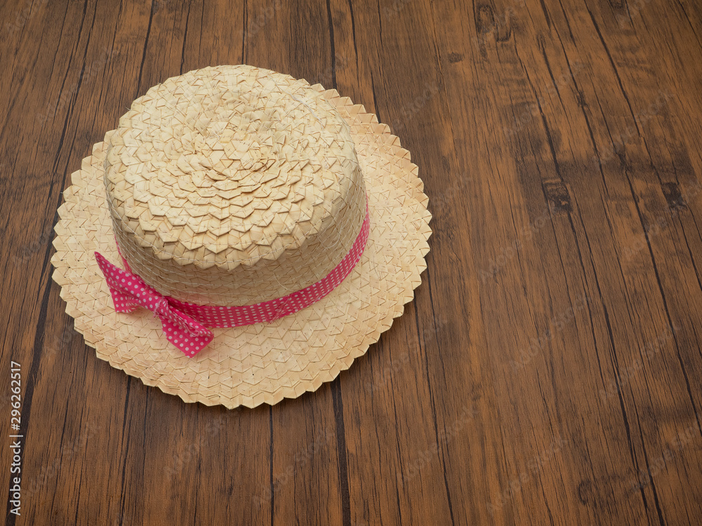 自然制作的帽子。木制桌子上有竹子，粉红色圆点织物。俯视图。