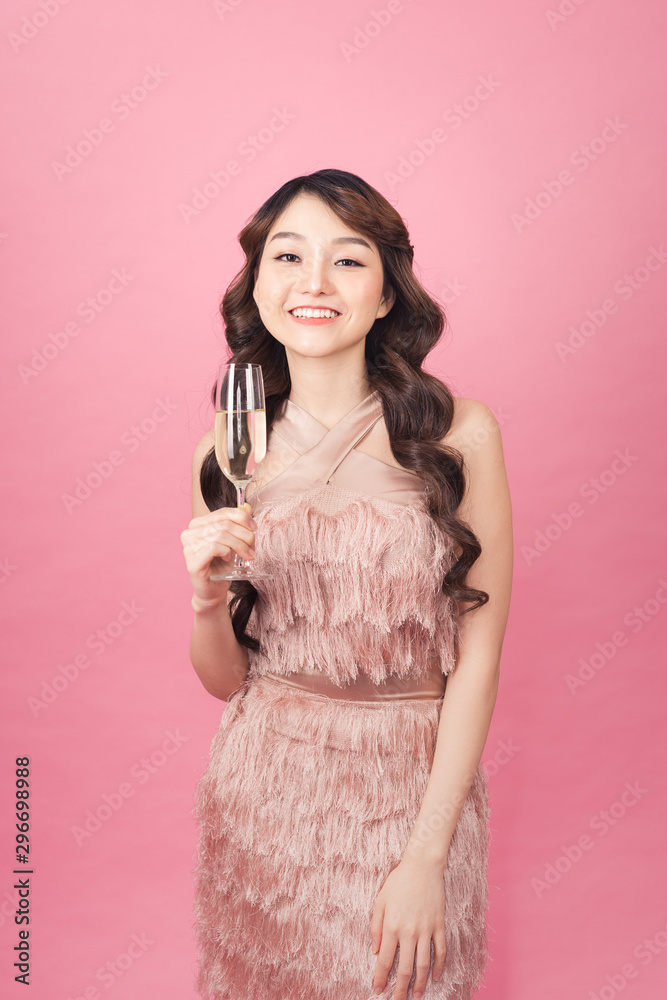 穿着时尚连衣裙的快乐女人拿着香槟，高兴地看着镜头。