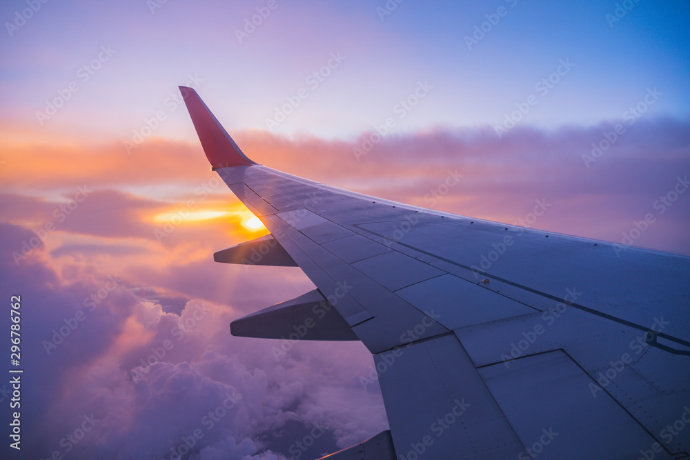 美丽的日落，俯视天空，从旅行的飞机内窗俯瞰飞机飞行