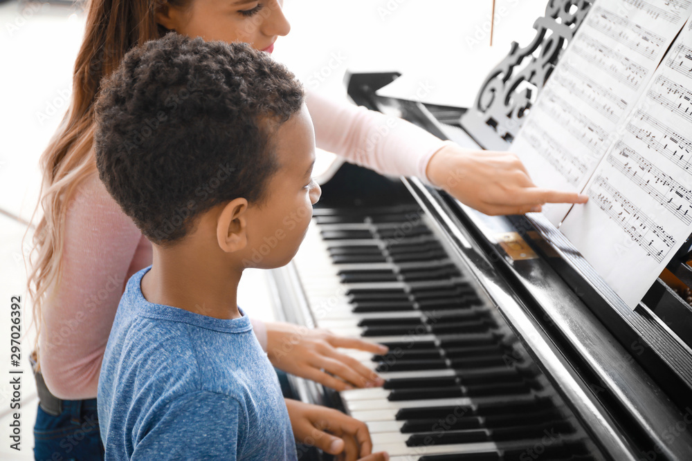 在家教非洲裔小男孩弹钢琴的女人