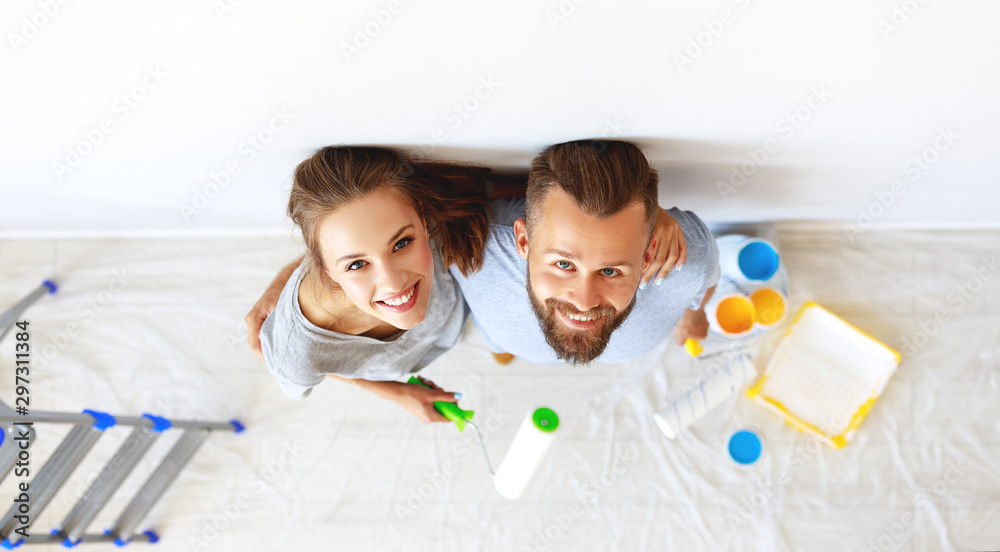 年轻幸福的夫妻在家修墙刷墙