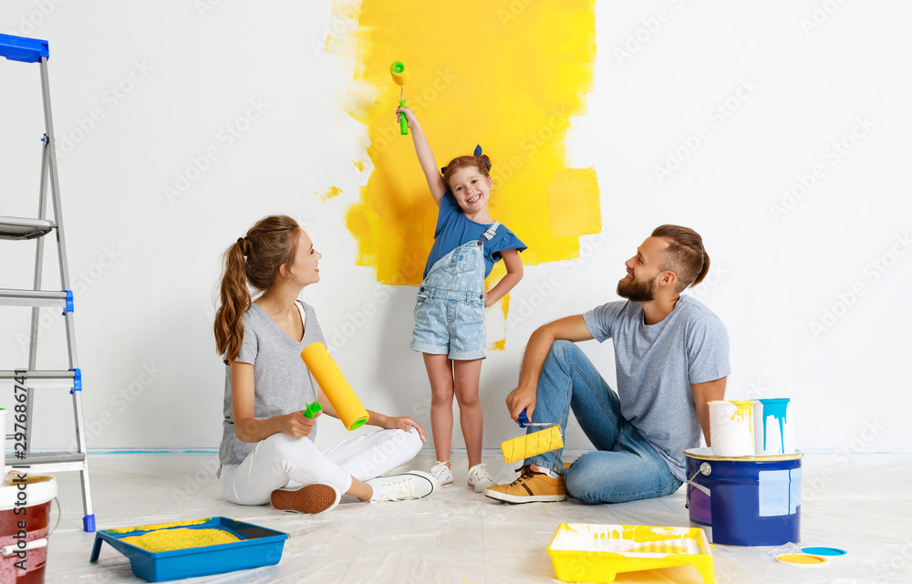 公寓维修。幸福的家庭母亲、父亲和孩子女儿粉刷墙壁