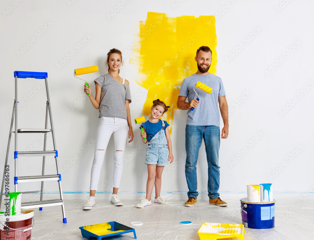 公寓维修。幸福的家庭母亲、父亲和孩子女儿粉刷墙壁