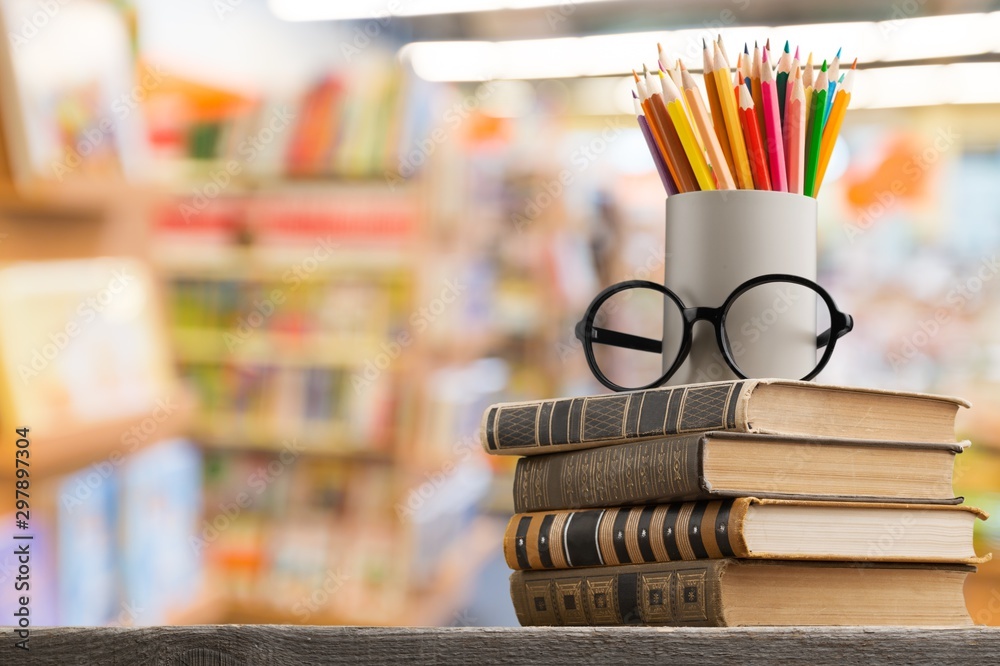 Stack of vintage books, eyeglasses and pencils, education and learning