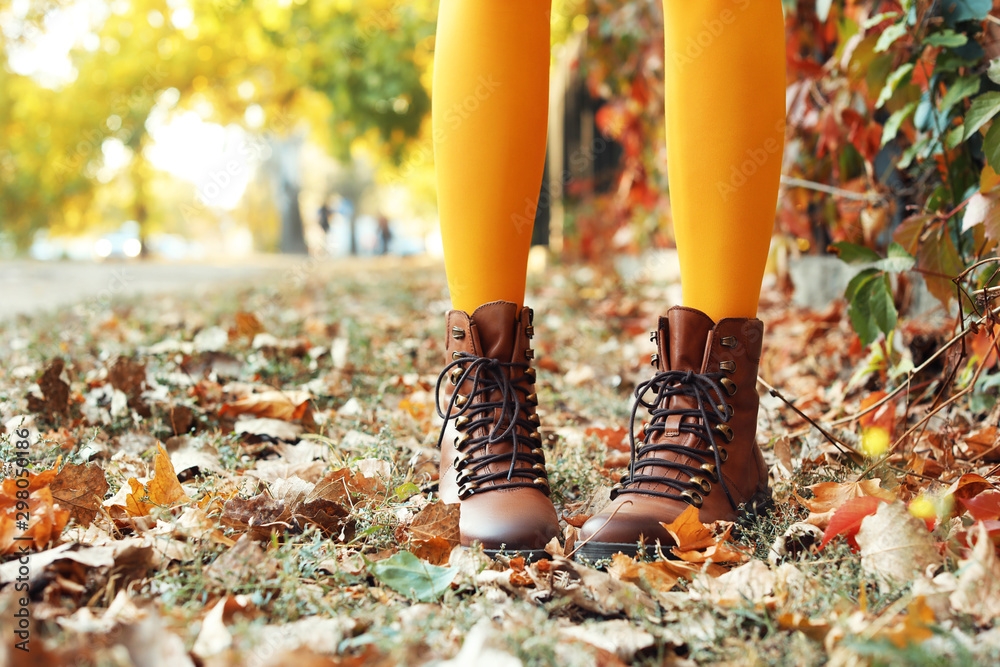 秋季公园里穿着时尚鞋子的年轻美女的腿