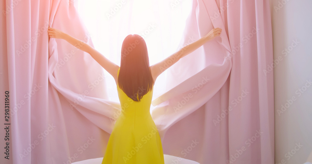 asian woman opening curtain