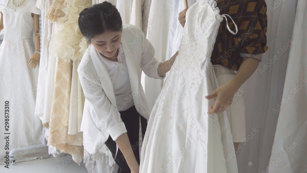 未来新娘顾客与婚纱店店主交谈，为其购买婚纱和配饰