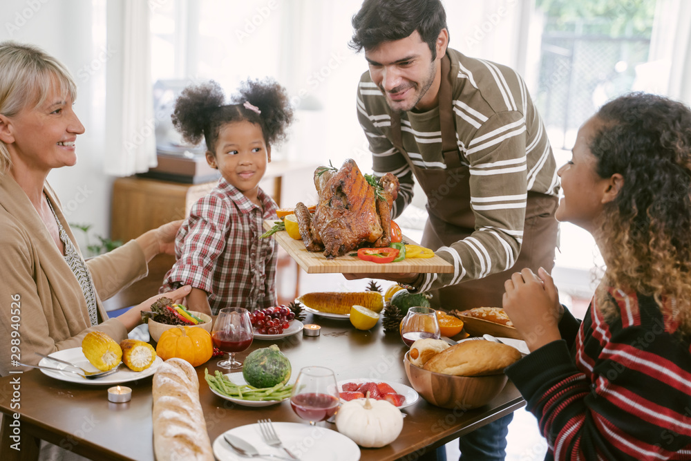 快乐家庭在家庆祝感恩节晚餐。庆祝传统概念