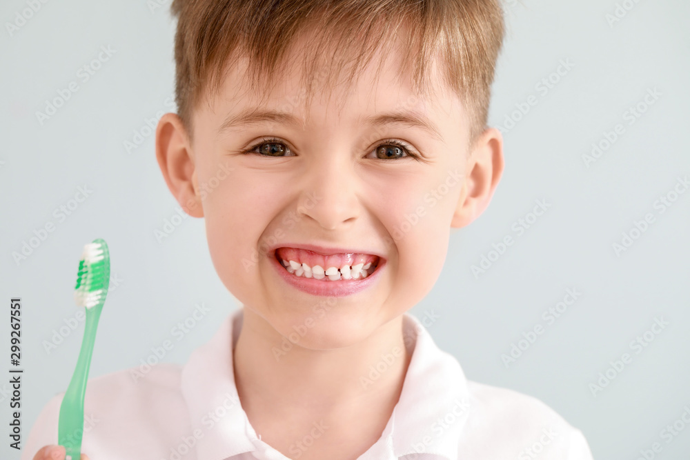 浅色背景下带牙刷的小男孩肖像