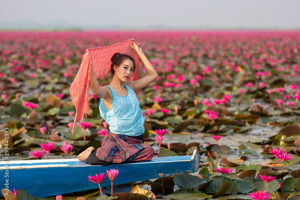 Woman on a boat in the lake red Lotus,Beautiful women in Lotus Gardens.