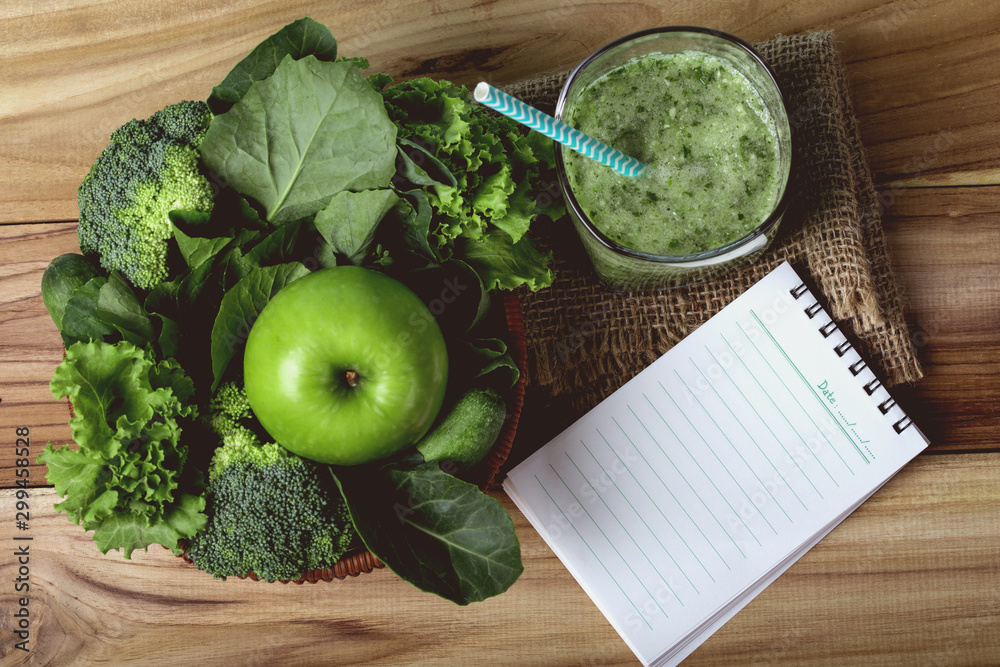将绿色蔬菜和绿色果汁放在篮子里，用木叉和spoo把绿色苹果收起来