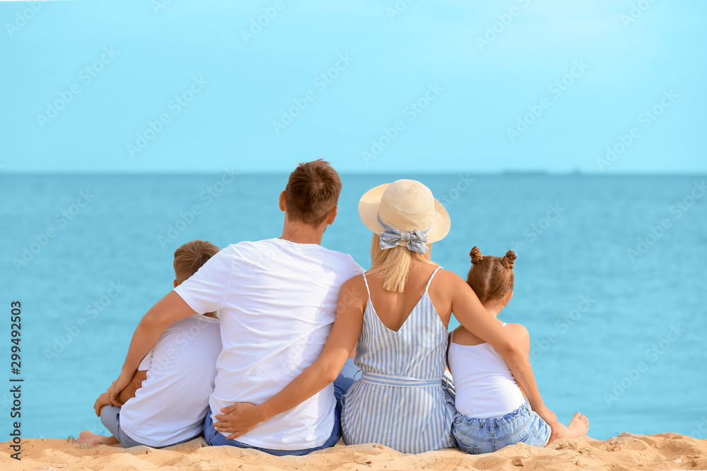 幸福的一家人坐在海边