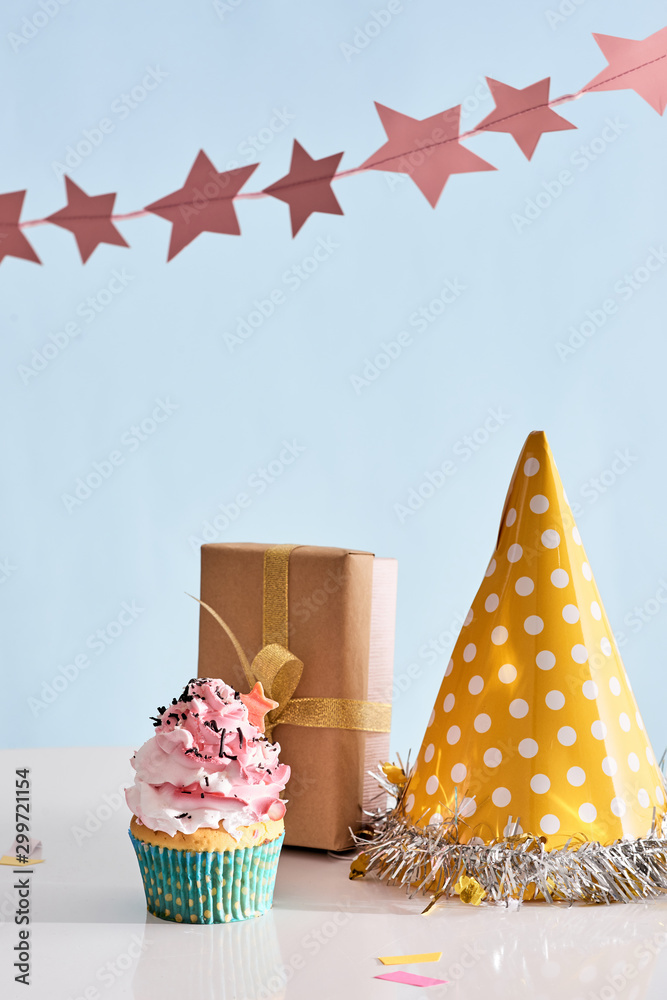 生日派对背景，配有纸杯蛋糕、派对帽子和礼物