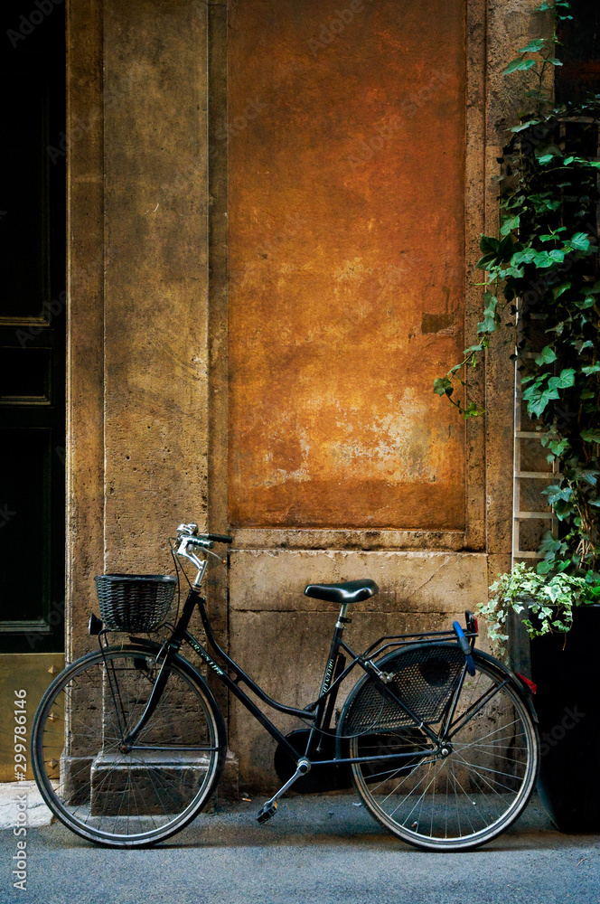 意大利罗马，一辆旧自行车靠在一堵古老的乡村风化墙上。