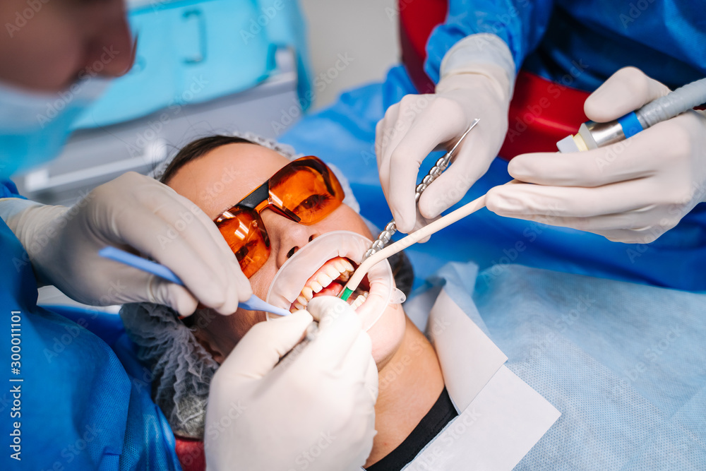 穿着制服的牙医在现代口腔科办公室为患者进行牙科治疗。选择性foc