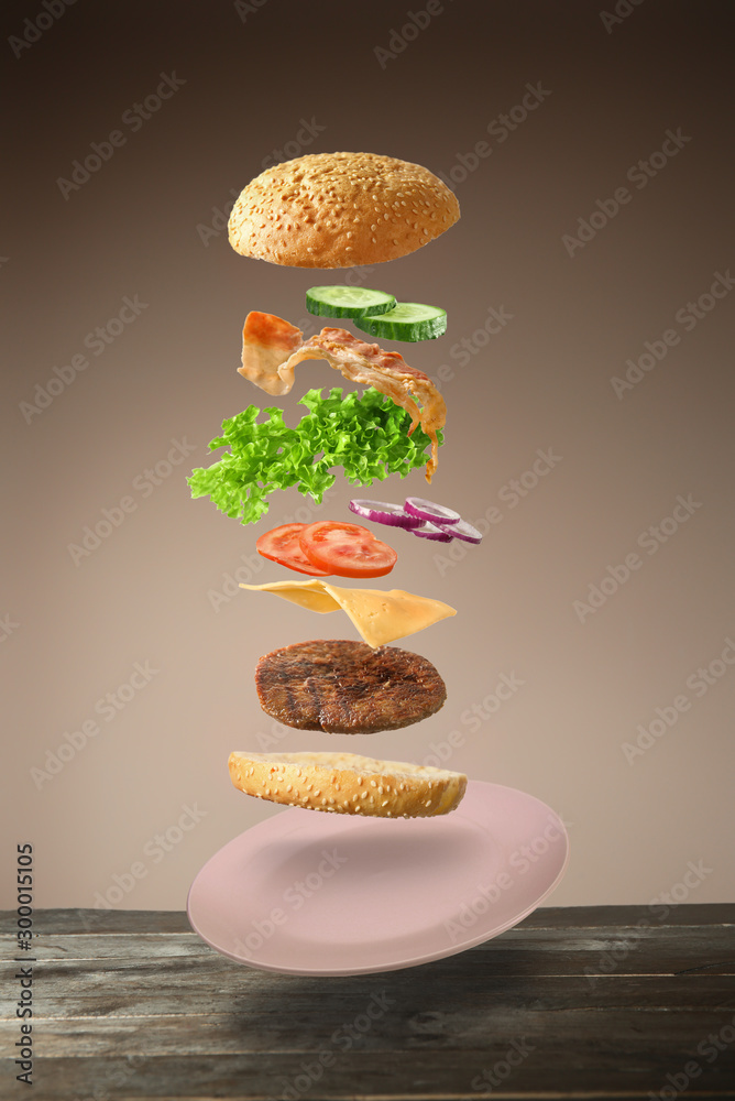 美味的汉堡，彩色背景上有飞行的成分