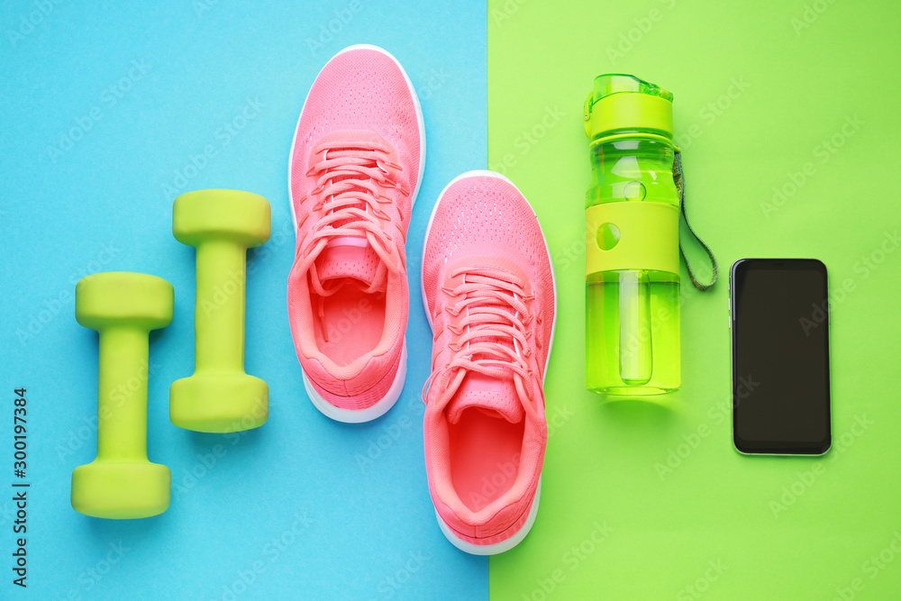 彩色背景运动水瓶、鞋子、手机和哑铃