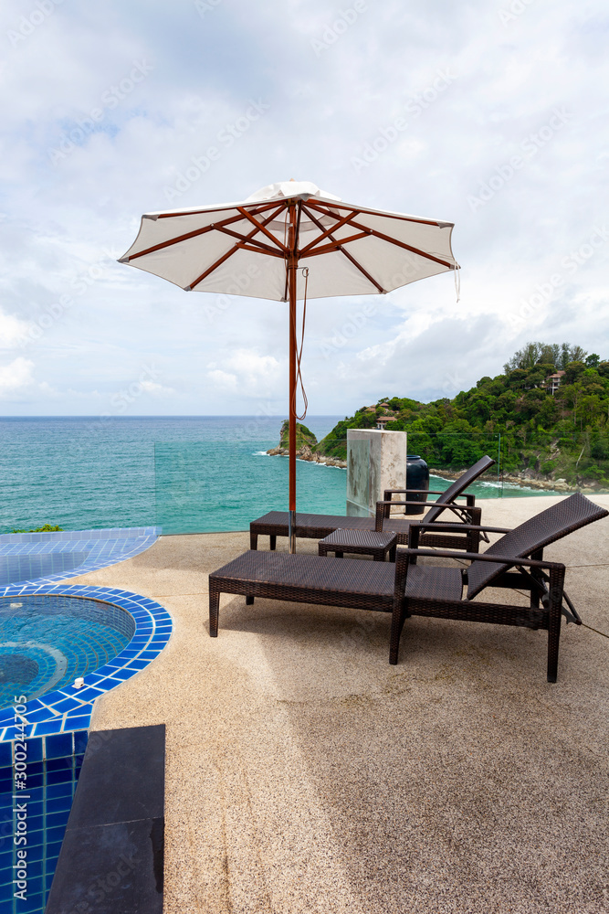 Beach chair in outdoor with swimming pool overlooking view tropical sea