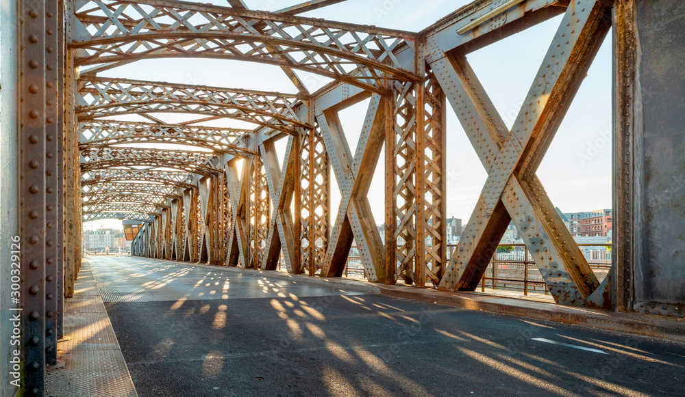 阳光明媚的日子里，城市桥梁钢结构下的沥青路。傍晚的城市场景
