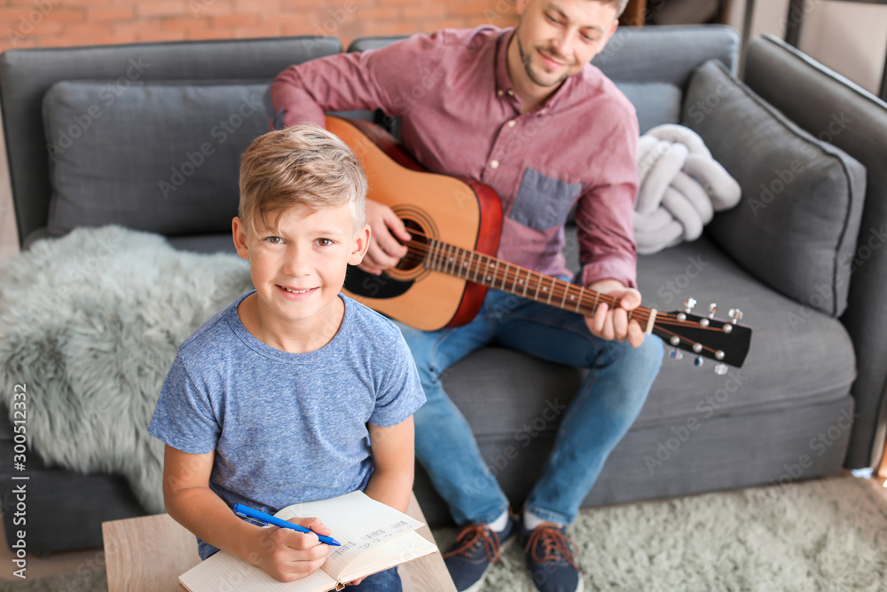 家里有吉他的小男孩和他的父亲