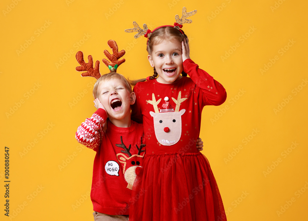 快乐、有趣、惊讶、情绪激动的孩子们穿着黄色圣诞驯鹿服装的男孩和女孩