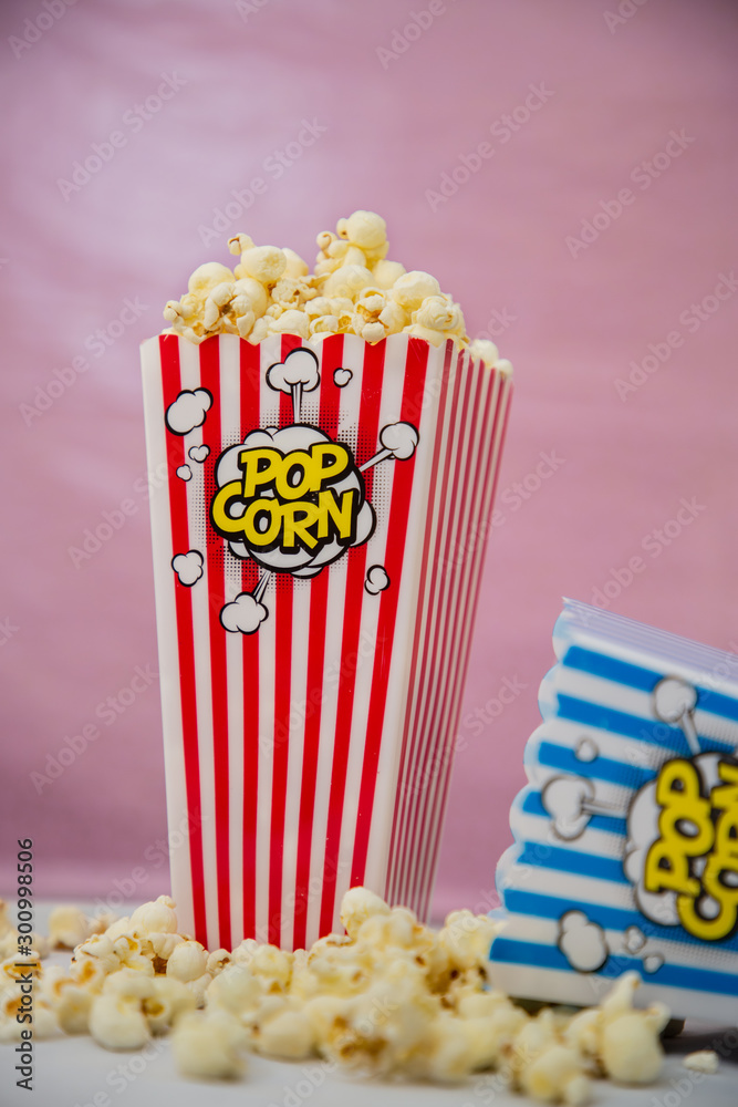 Buttered movie popcorn in a popcorn cup on white background