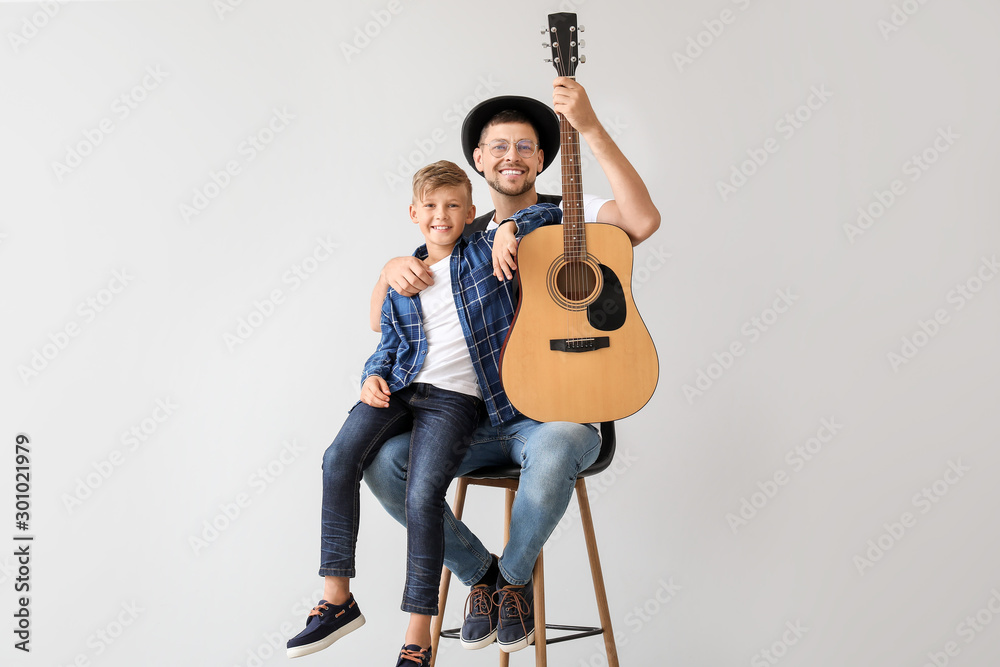 英俊的男人和他的小儿子，轻背景吉他