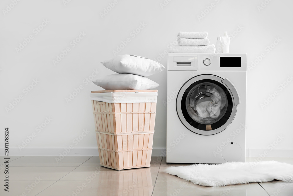 现代洗衣机，靠近浅色墙壁的洗衣房