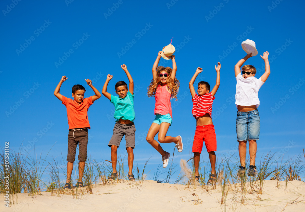 一群快乐的小孩在沙丘上跳跃