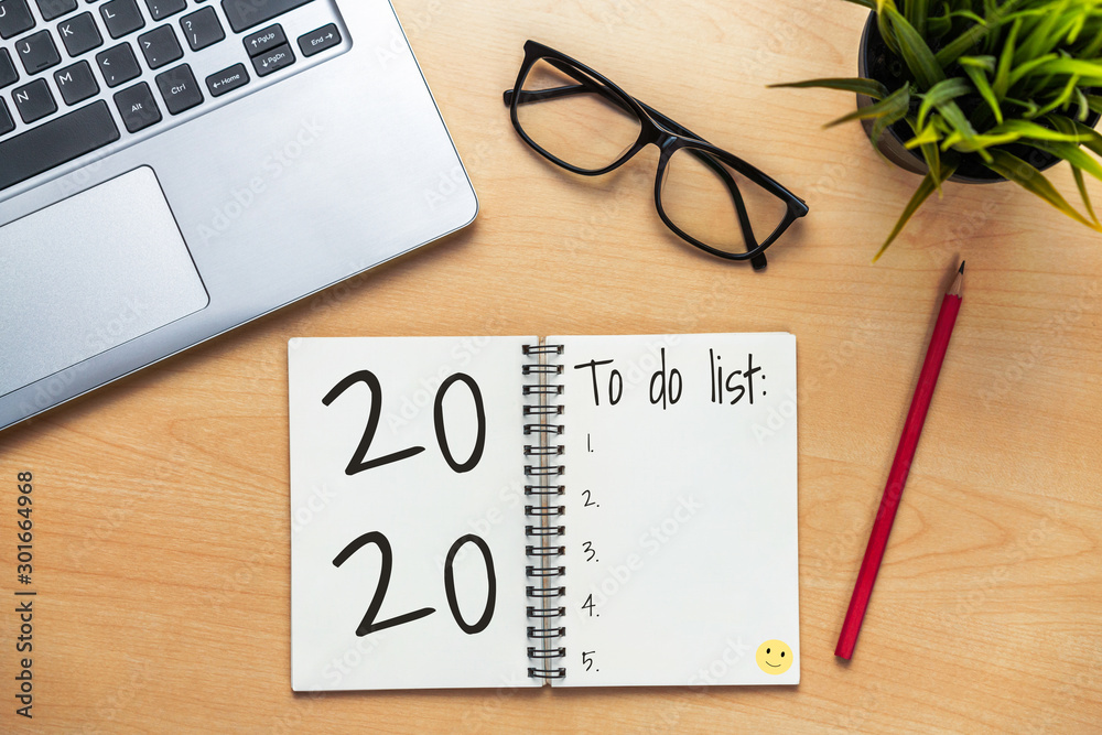 New Year Resolution Goal List 2020 - Business office desk with notebook written in handwriting about