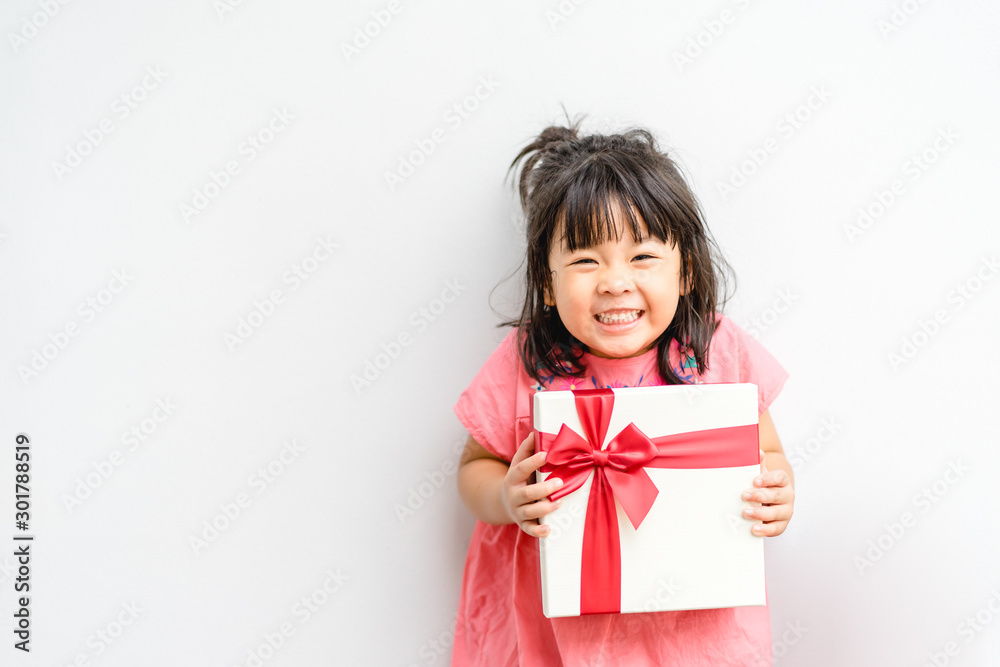 Little asian girl smile and excited and holding red gift box on white background.child holding gift 