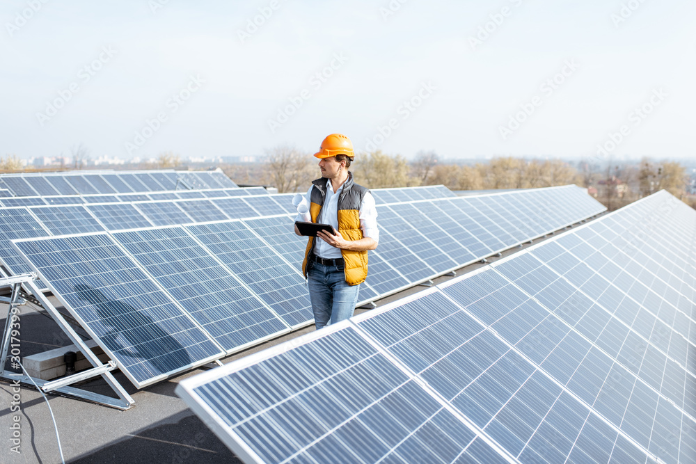 曼在屋顶太阳能发电厂散步，检查光伏电池板。概念o